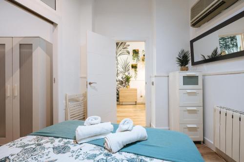 ein Schlafzimmer mit einem Bett mit Handtüchern darauf in der Unterkunft Divi Apartments Martínez Montañes in Sevilla