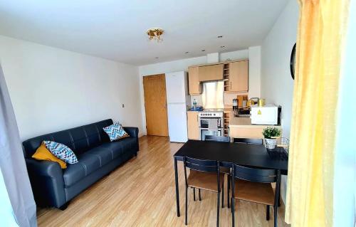 ein Wohnzimmer mit einem Sofa und einem Tisch sowie eine Küche in der Unterkunft Lovely 5 Sleeper Flat - Upper Clapton in London