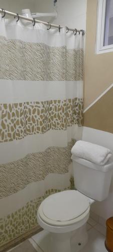 a bathroom with a toilet and a shower curtain at Loft 2 Quadras da Praia do Recreio in Rio de Janeiro