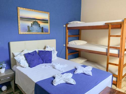 um quarto com 2 beliches e uma parede azul em Pousada do Luar Cabo Frio em Cabo Frio
