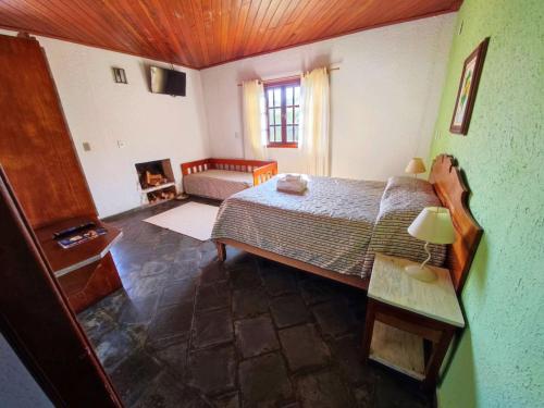 - une chambre avec un lit et un canapé dans l'établissement Pousada Green Valley, à São Roque