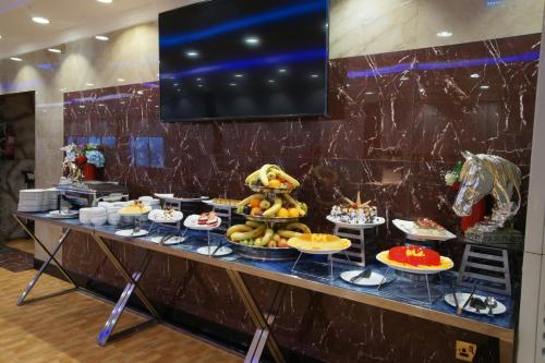 a buffet line with cakes and desserts on display at Al Azhar Hotel Jeddah in Jeddah