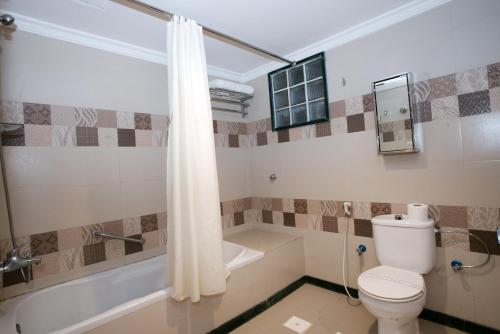 a bathroom with a toilet and a bath tub at Al Azhar Hotel Jeddah in Jeddah
