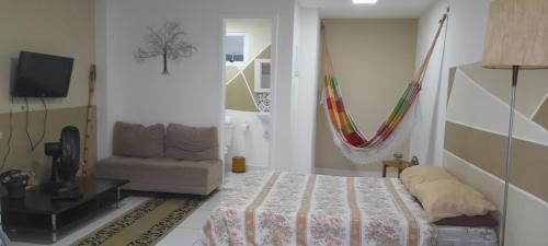 a bedroom with a bed and a hammock in it at Loft 2 Quadras da Praia do Recreio in Rio de Janeiro