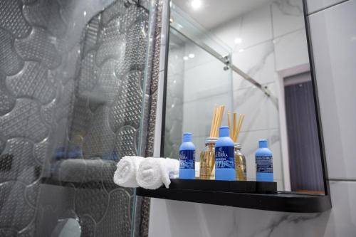 a shelf in a bathroom with blue bottles and towels at Natali luxury suites- mini rooms in Belgrade