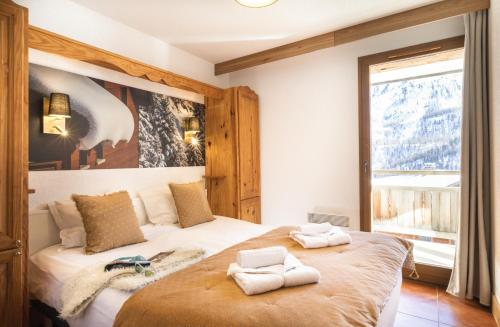 a bedroom with a bed with two towels on it at Résidence Club mmv Le Hameau des Airelles **** in Montgenèvre