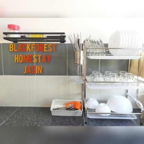 a kitchen with a shelf with dishes and utensils at HOMESTAY JASIN BLACKFOREST in Jasin