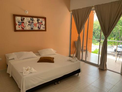 ein Schlafzimmer mit einem Bett mit weißen Bögen darauf in der Unterkunft Hotel Inversiones Napoles in Doradal