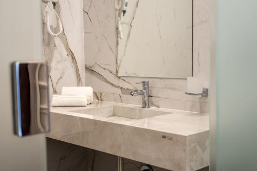 a bathroom with a sink and a mirror at Hotel XBusiness in Nola