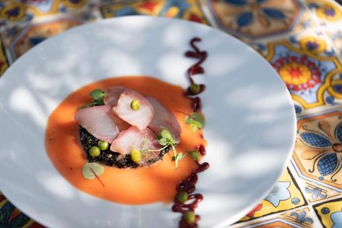 a white plate with food on a table at Hotel Villa Dorata in Nicolosi