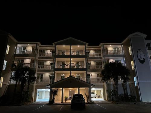 a large apartment building at night with a car parked in front at Caddyshack Condo in Big Blackjack Landing