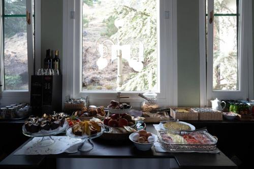 a table topped with lots of food and bottles of wine at Hotel Villa Dorata in Nicolosi