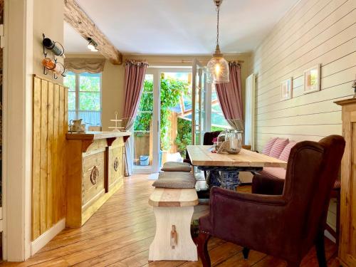 a living room with a wooden table and a dining room at Weißt Du noch - Gästehäuser & Suiten in Kühlungsborn