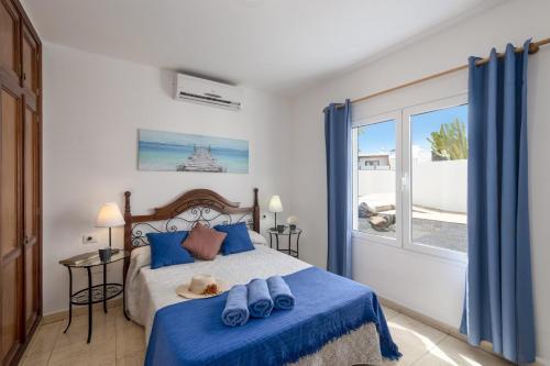 ein Schlafzimmer mit einem Bett mit blauen Handtüchern darauf in der Unterkunft Villa Almar by Villa Plus in Tías