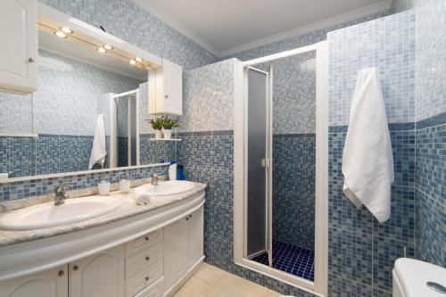 a blue tiled bathroom with a sink and a shower at Villa Almar by Villa Plus in Tías