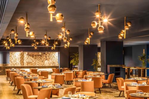a dining room with tables and chairs and chandeliers at Pickalbatros Blu Spa Resort - Adults Friendly 16 Years Plus- Ultra All-Inclusive in Hurghada