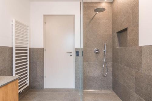 La salle de bains est pourvue d'une douche avec une porte en verre. dans l'établissement Hofer Hof Ziel, à Lagundo