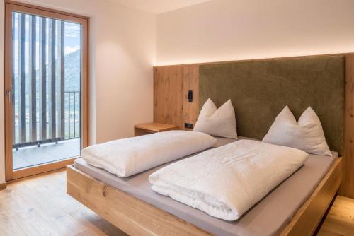 una camera da letto con un grande letto con una grande finestra di Hofer Hof Ziel a Lagundo