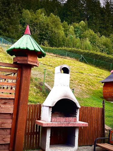 a outdoor pizza oven with a roof on a fence at Apartments Ve dvoře in Velké Karlovice
