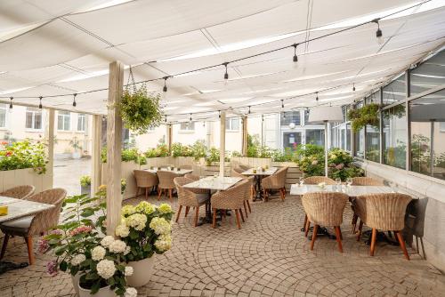 un restaurante con mesas, sillas y flores en Red Stars Hotel, en San Petersburgo