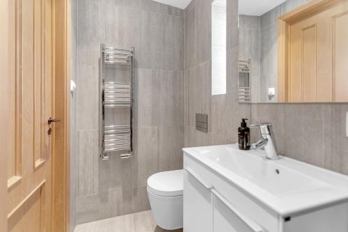uma casa de banho com um lavatório branco e um WC. em Luxurious Private Villa em Reiquiavique