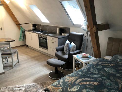 RommerskirchenにあるCharmante Ferienwohnungen auf Reitstall Wasserburg Anstel - ein Ort zum Wohlfühlen und Entspannenのベッド1台付きの部屋、テーブル付きのキッチンが備わる客室です。