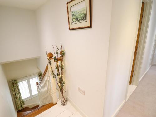 a hallway with a staircase with a picture on the wall at Tan Y Ddol in Welshpool
