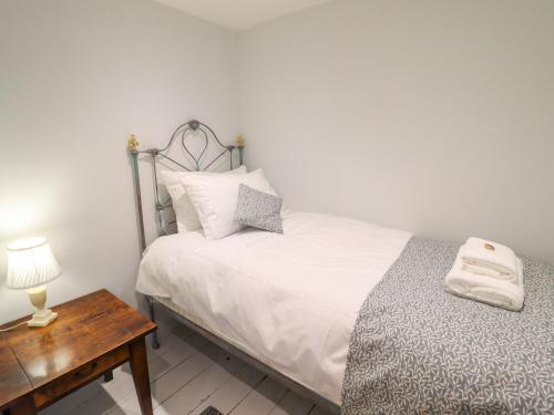 a small bedroom with a bed and a table at Tan Y Ddol in Welshpool