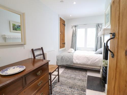 a bedroom with a bed and a dresser and a desk at Tan Y Ddol in Welshpool