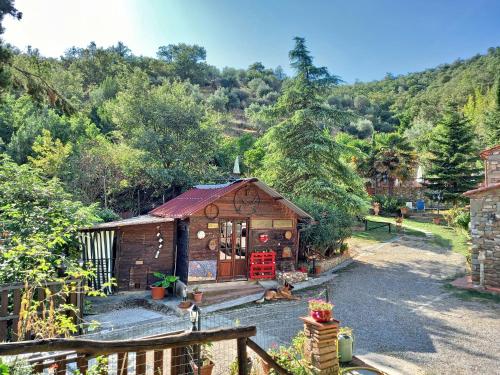 una pequeña casa de madera con una valla y árboles en Casa Le Celle en Cortona