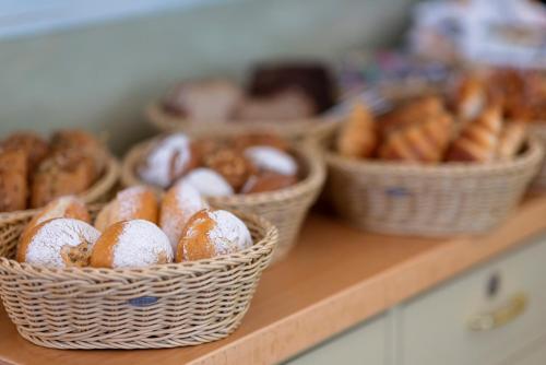 a bunch of donuts in baskets on a counter at Hotel Minerva in Freiburg im Breisgau