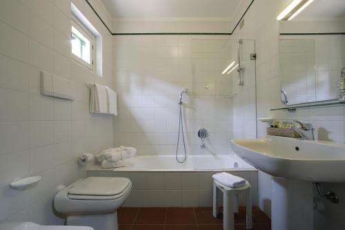 a white bathroom with a toilet and a sink at Hotel & Resort Sant'Anna Del Volterraio in Portoferraio