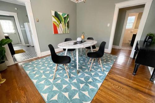 a dining room with a table and chairs on a blue rug at Historic Revival 2BR Midtown Memphis Fast Wifi Free Parking Yes Pets in Memphis