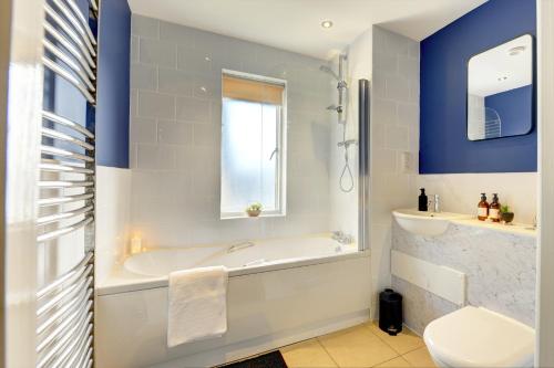 a bathroom with a tub and a toilet and a sink at Spacious - PENTHOUSE 2 Bed Apartment with secure allocated parking in Sheffield