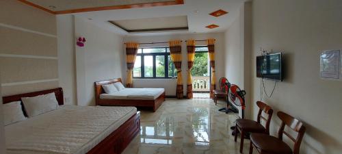 a bedroom with a bed and a couch and a tv at Motel Quốc Việt in Bà Rịa