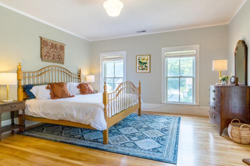 a bedroom with a bed and a dresser and two windows at The School House - Walk to all Shops and Restaurants - New Remodel in Manchester