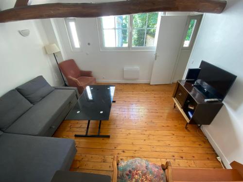 een woonkamer met een bank en een tv bij Maison Individuelle avec jardin privatif in Avon