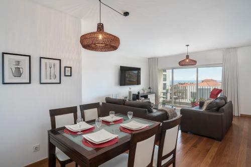 a dining room and living room with a table and chairs at Santa Luzia II by An Island Apart in Funchal