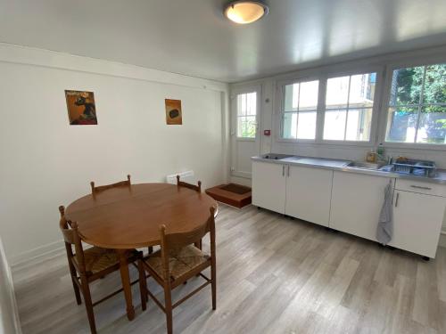 een keuken met een houten tafel en een tafel en stoelen bij Maison Individuelle avec jardin privatif in Avon