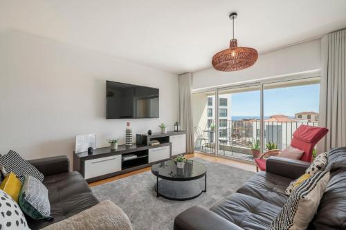 a living room with a couch and a tv at Santa Luzia II by An Island Apart in Funchal