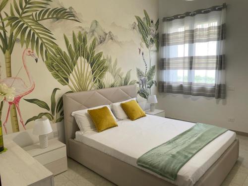 a bedroom with a bed with yellow pillows and plants at tropical loft in Salemi