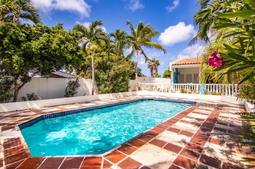 a swimming pool in the backyard of a house with palm trees at Aqualife 3 Palabrua in Vredeberg