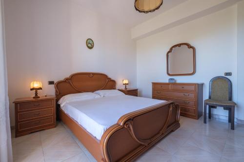 - une chambre avec un lit, un miroir et une chaise dans l'établissement Villa Delle Pomelie, à Torre Forte