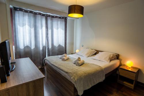 ein Schlafzimmer mit einem Bett mit zwei Handtüchern darauf in der Unterkunft 15 Rhône beau T2 avec parking gratuit in Annecy
