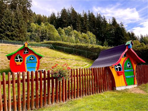 two colorful playhouses behind a wooden fence at Apartments Ve dvoře in Velké Karlovice