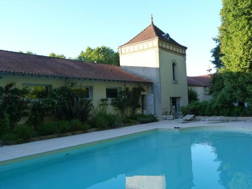 a house with a swimming pool in front of a building at Domaine de Cremens 