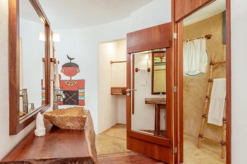 a bathroom with a mirror and a sink at Dos Ceibas Tulum Feel Good Hotel in Tulum