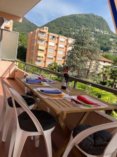 a wooden table with a bottle of wine on a balcony at Lugano Viganello in Lugano