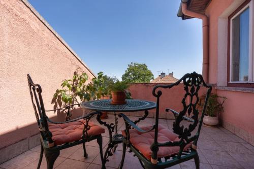 a table and two chairs on a balcony at Villa-Hotel Escala in Cluj-Napoca