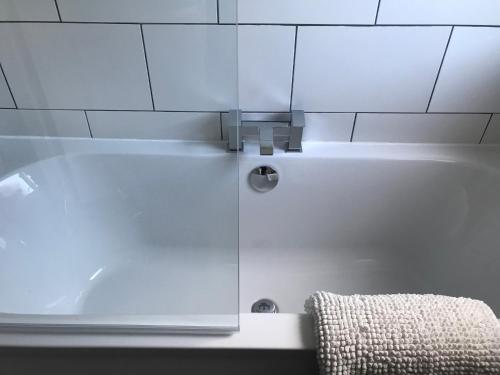 a white bath tub in a bathroom with a towel at Riverside home. 3 bedroom. Free parking. 10 mins to Newcastle City Centre in Dunston